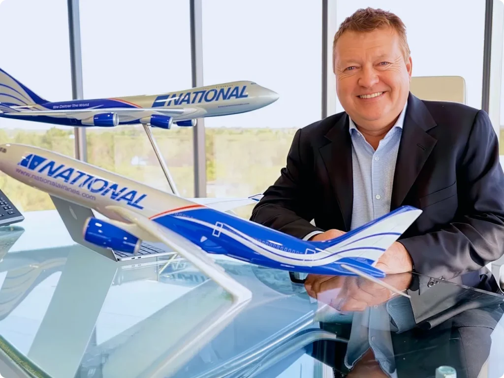 National Air Cargo chairman next to airplane models.