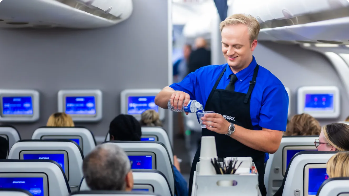 A flight attendant preparing a drink for a passenger